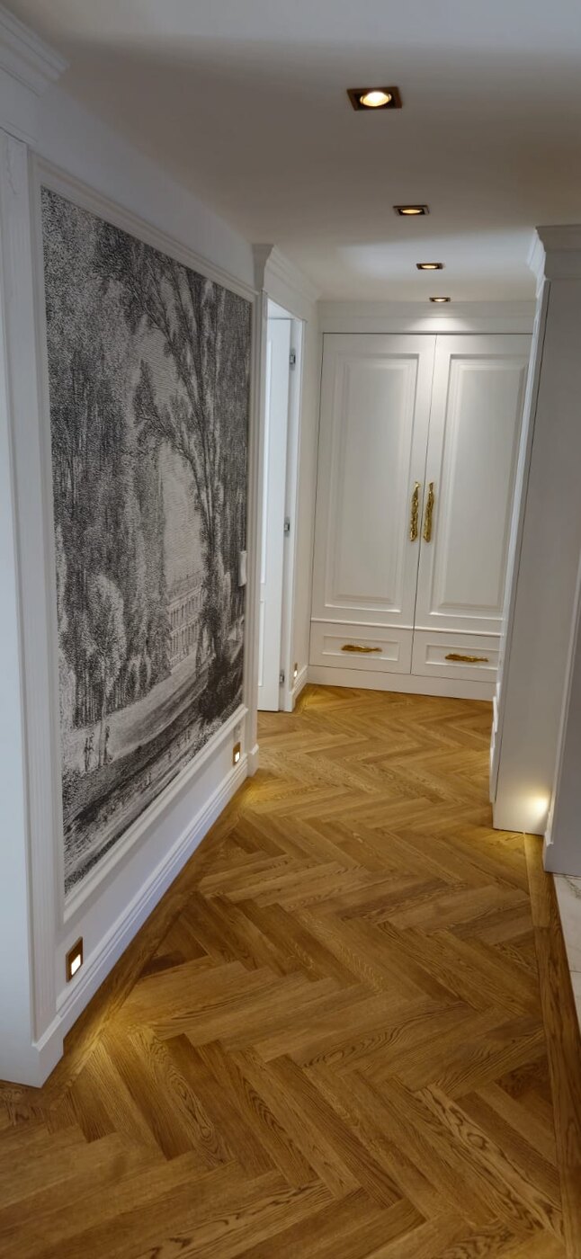 Flur mit weißem Einbauschrank und Eichen-Fischgrät-Parkett